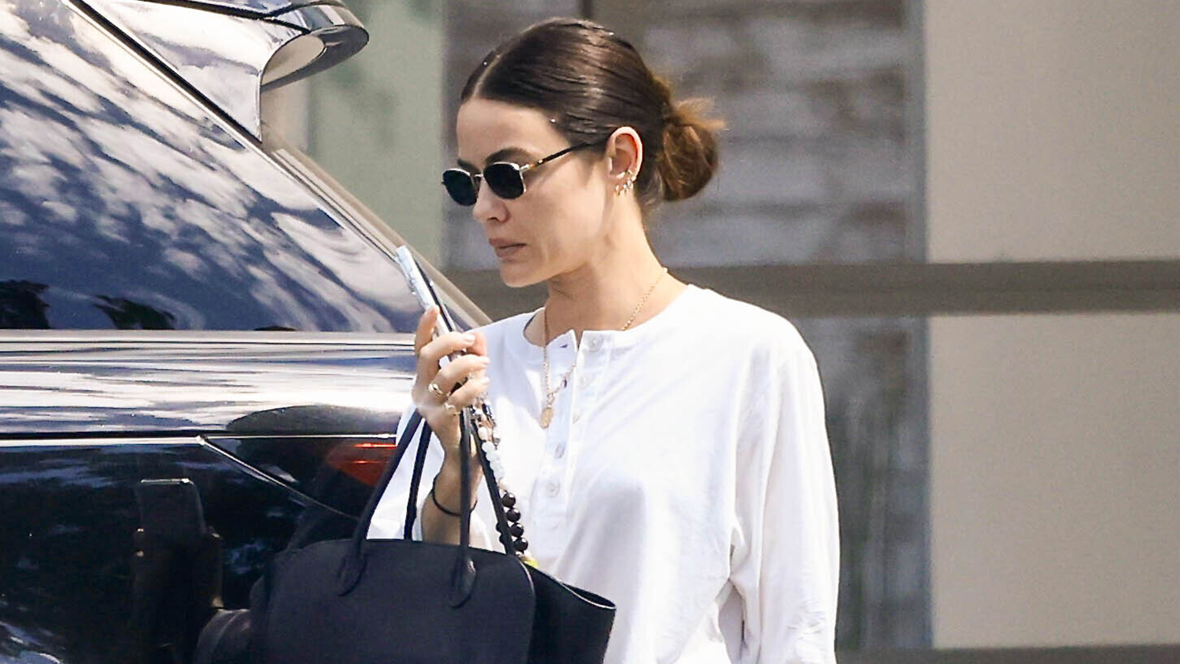 Lucy hales wears a white henley t-shirt with the row marlo bag.