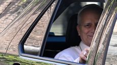 Pope Leo XIV waves from the window of a car as he leaves the Vatican before being admitted to Rome's Gemelli University Hospital