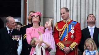 Members of the Royal Family (L-R) Britain's Prince Philip, Duke of Edinburgh, Britain's Prince Harry, Britain's Catherine, Duchess of Cambridge (with Princess Charlotte and Prince George), and Britain's Prince William, Duke of Cambridge, stand on the balcony of Buckingham Palace to watch a fly-past of aircraft by the Royal Air Force, in London on June 17, 2017.