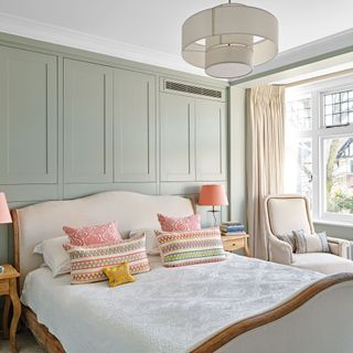 Main bedroom with upholstered bed and pastel colour accents