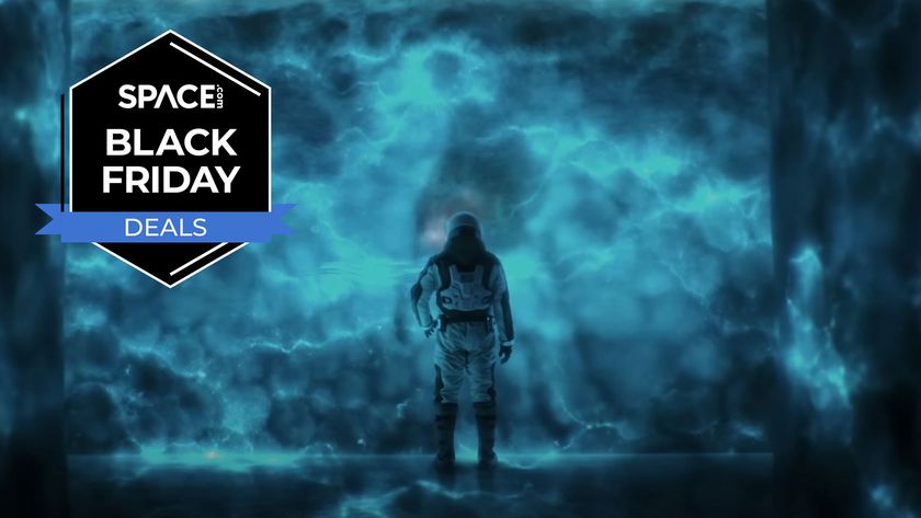 A man in a space suit looks on at a blue glow against a wall with the space.com logo in the top left corner.