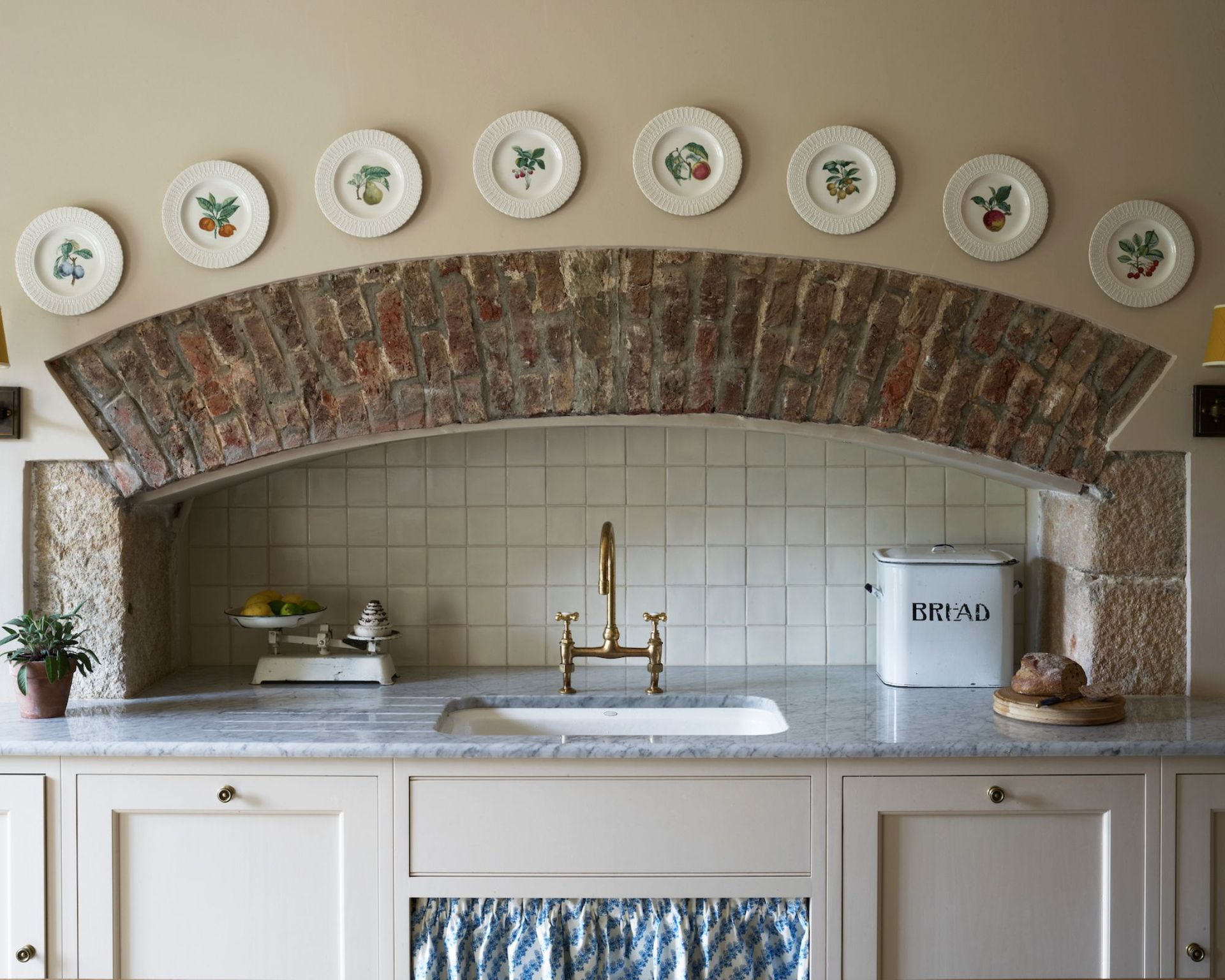 An old fireplace is turned into a sweet sink area, framed by hanging plates