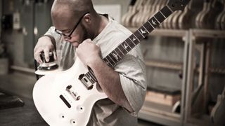 Man building a PRS guitar