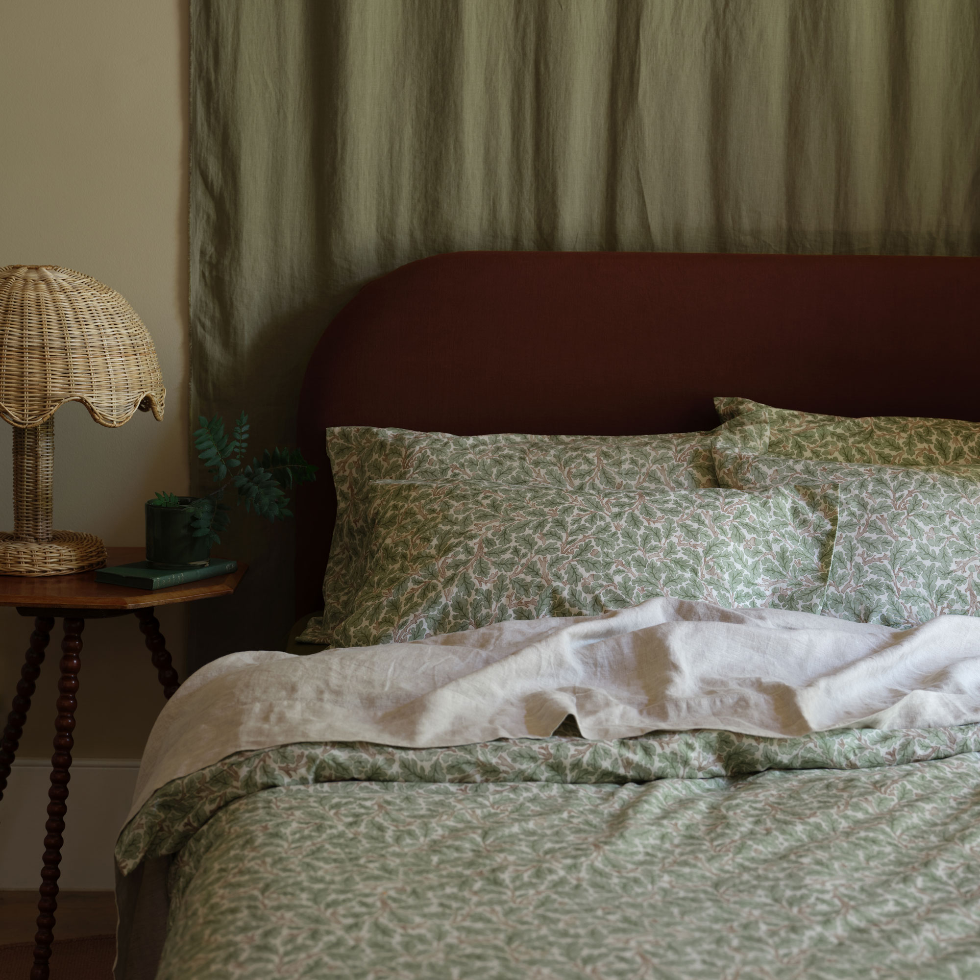 Piglet in Bed Morris and Co bedding in green with red headboard