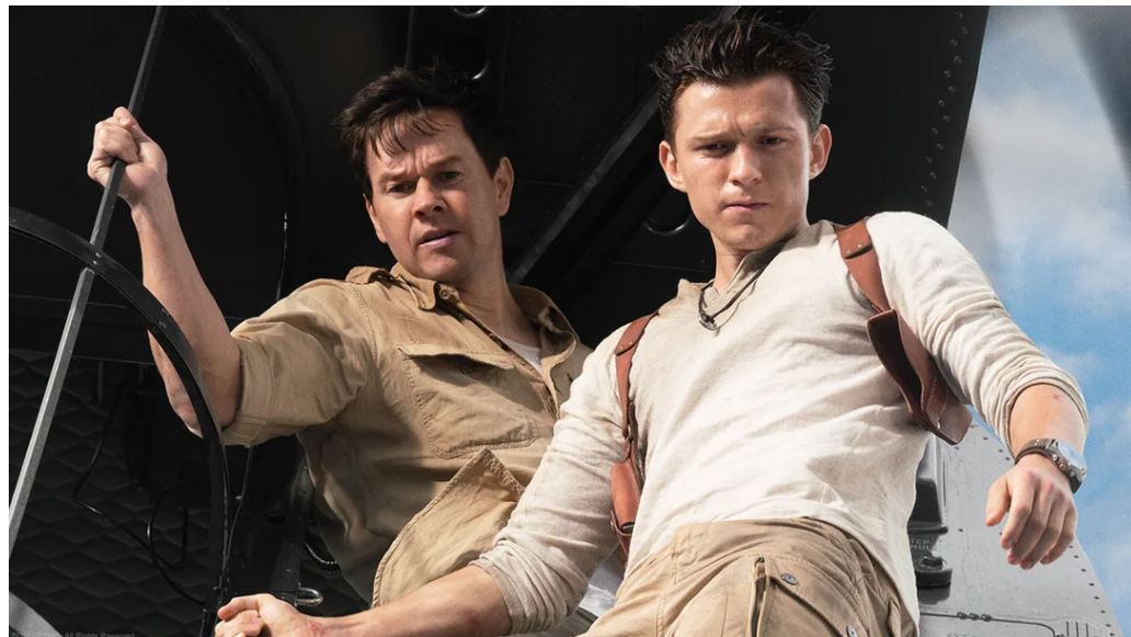 Sully and Drake looking down at something in the Uncharted movie.