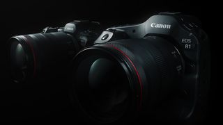 Canon EOS R1 camera in front of a Canon EOS R5 Mark II camera with most of the cameras shrouded in darkness