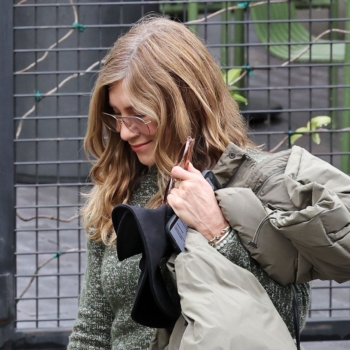 Jennifer Aniston and new boyfriend Jim Curtis at an event in Summerland, CA, wearing cigarette jeans from R13 with a green sweater and black pointed-toe boots.