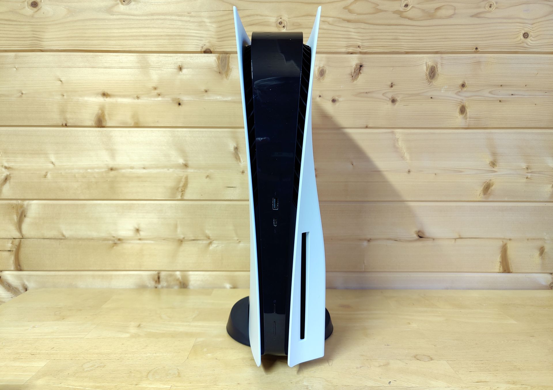 The PS5 console in vertical orientation, attached to its black base