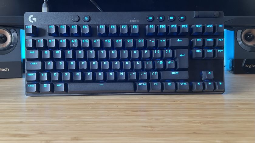 Logitech G Pro X TKL Rapid gaming keyboard on a wooden desk with blue lighting