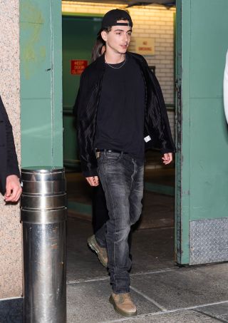 Timothee Chalamet in Midtown in jeans and backwards baseball cap heading to Dune Part Two Event.