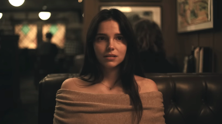 Inde Navarette sitting down at a restaurant booth as Nikki in Obsession