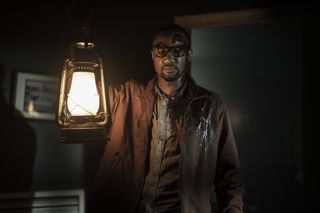 An unknown character stands with a lamp on Tales of the Walking Dead