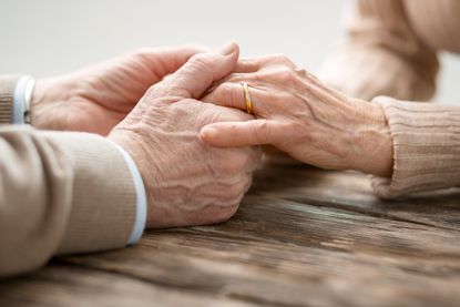An elderly couple holding hands.