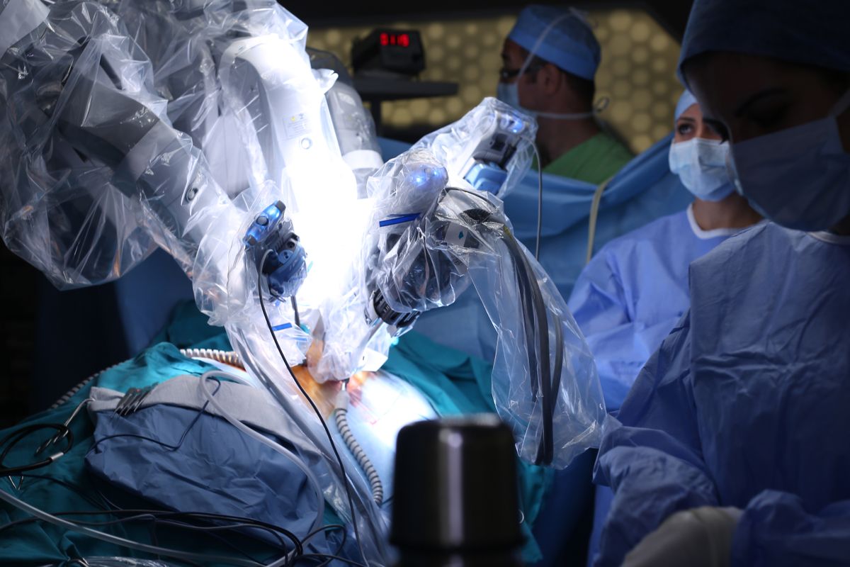 Doctors watching a robot perform surgery