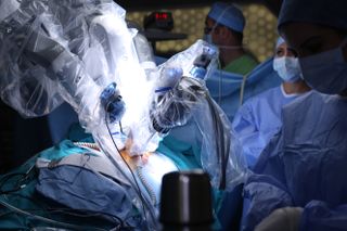 Doctors watching a robot perform surgery