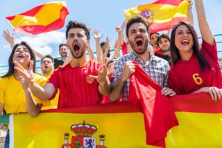 People cheering on Spain for a sports game.