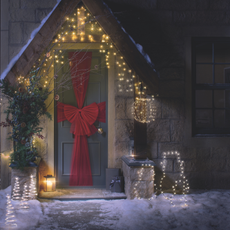 Red mesh Aldi door bow on a sage green front door.