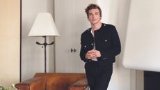 Jeremiah Brent standing in a white room wearing a black jacket