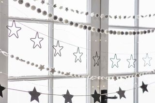 Felt pompom and star festive garlands strung across window