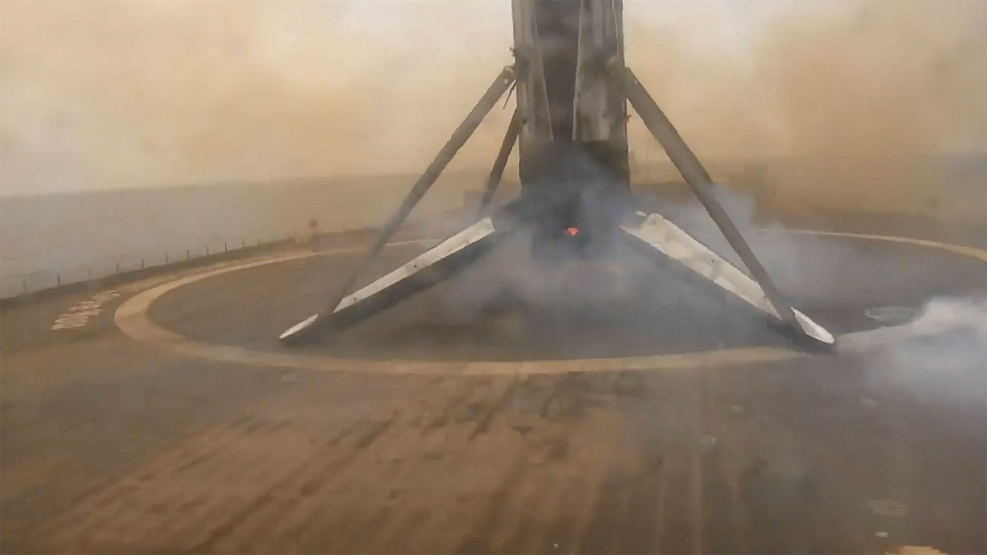 a rocket's first stage stands atop a sea-based droneship after landing on its four deployed legs