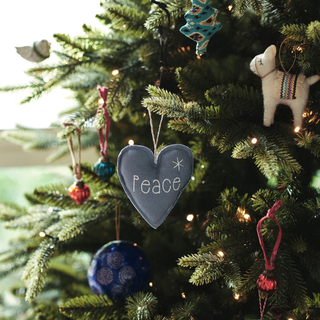 Felt bauble in shape of heart. It's blue and says 'Peace on it'. It's hung a green tree