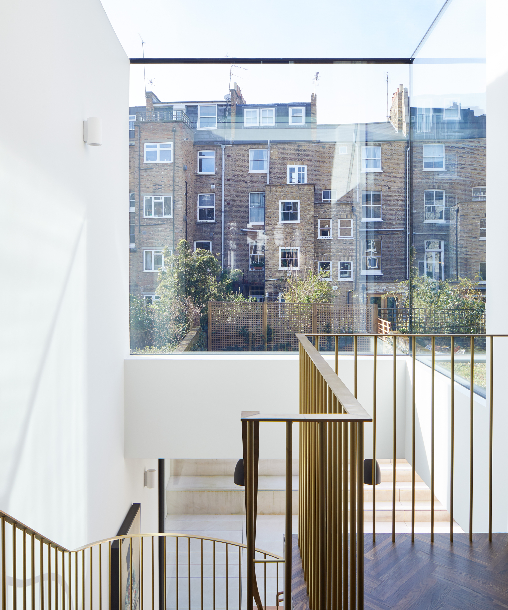metal staircase in double height space with glass corner wall and glazed roof