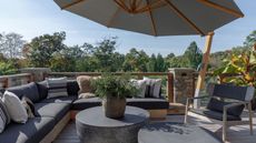 Outdoor balcony terrace with L-shape sofa and parasol
