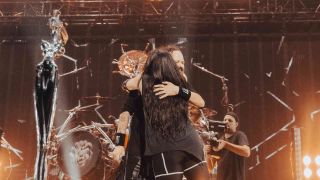 Amy Lee and Jonthan Davis hugging each other onstage
