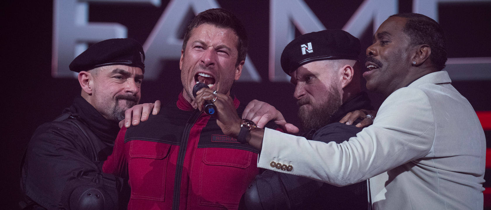 Glen Powell as Ben Richards yells into a microphone in The Running Man