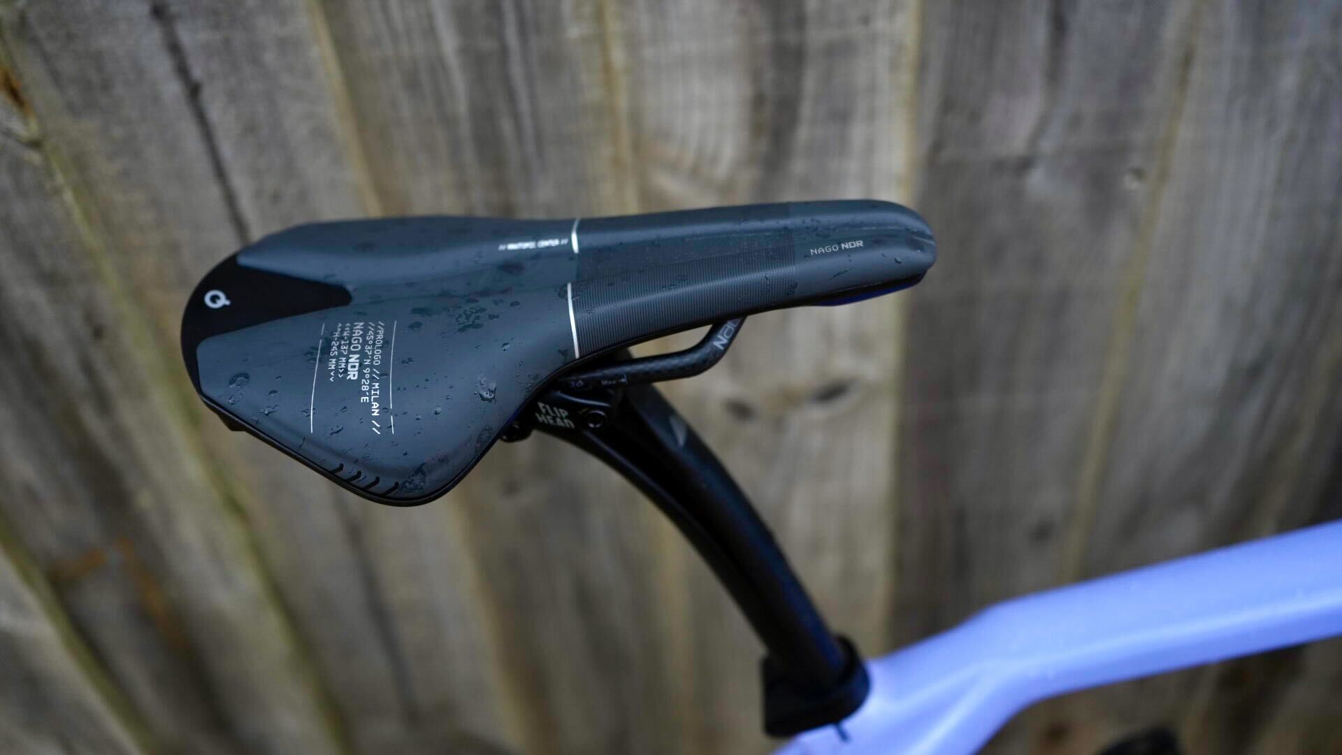 Gravel bike with prologo NDR saddle against a wooden fence
