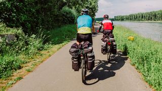 Bikepackers riding beside canal