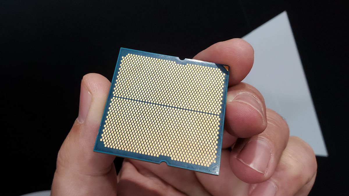 Image of an AMD Ryzen 9000 series processor, with the headspreader removed, held in a hand