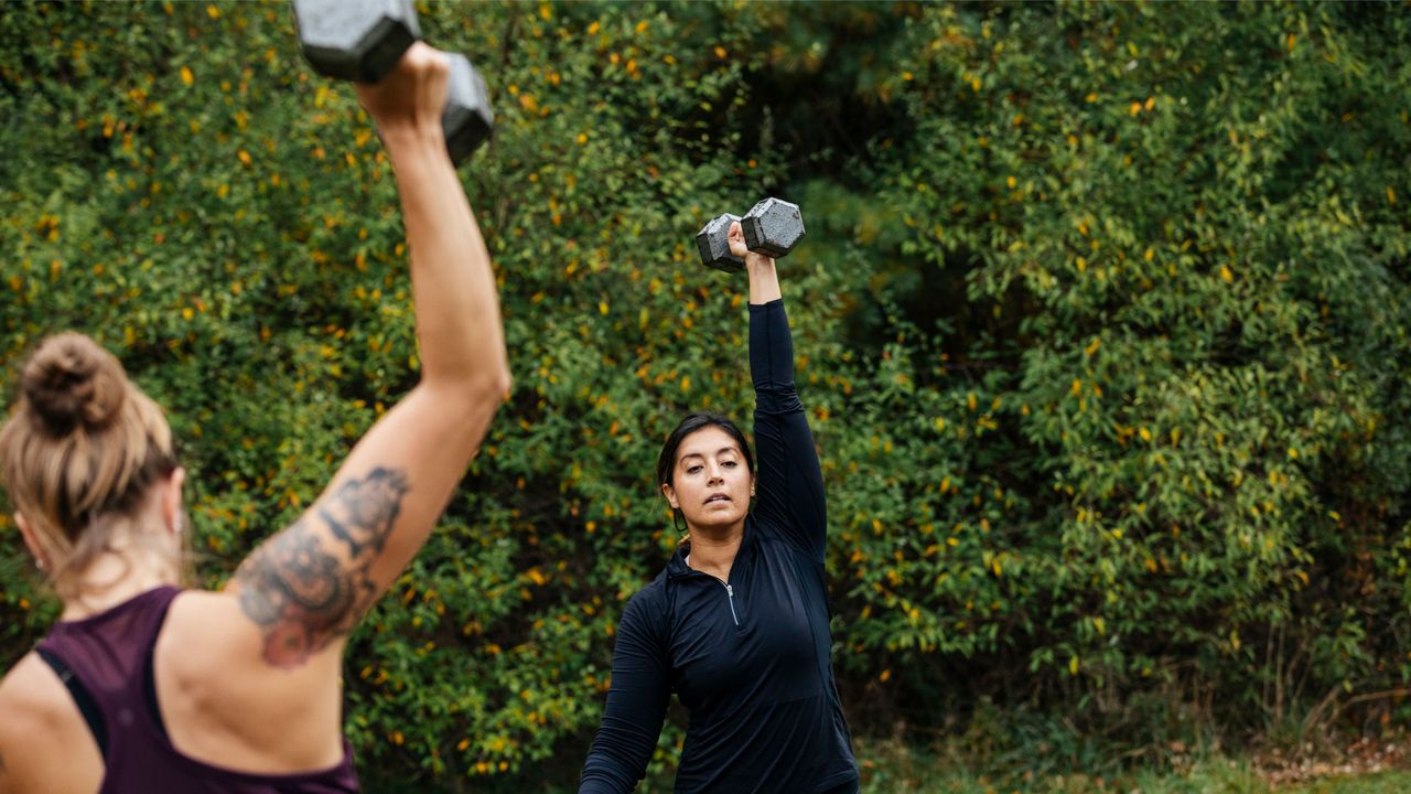 Two women lifting free weights.