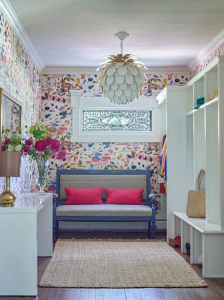 pretty mudroom with bright floral wallpaper and bench with pink cushions