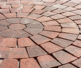 Paving circle of red stones as a robust and decorative flooring in the garden and as a walkway