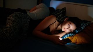 Una persona mirando el móvil en la cama por la noche