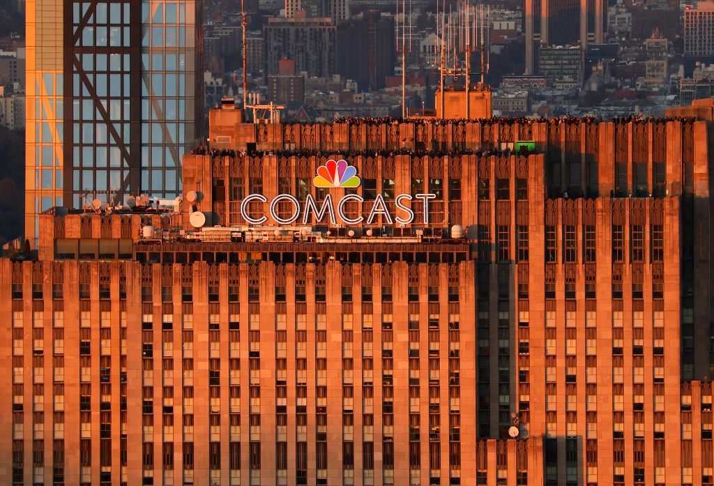 The sun sets on the Comcast corporate logo at the top of 30 Rock building in New York City