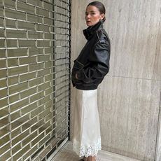 @rikkekrefting wearing leather jacket, lace skirt, black heels