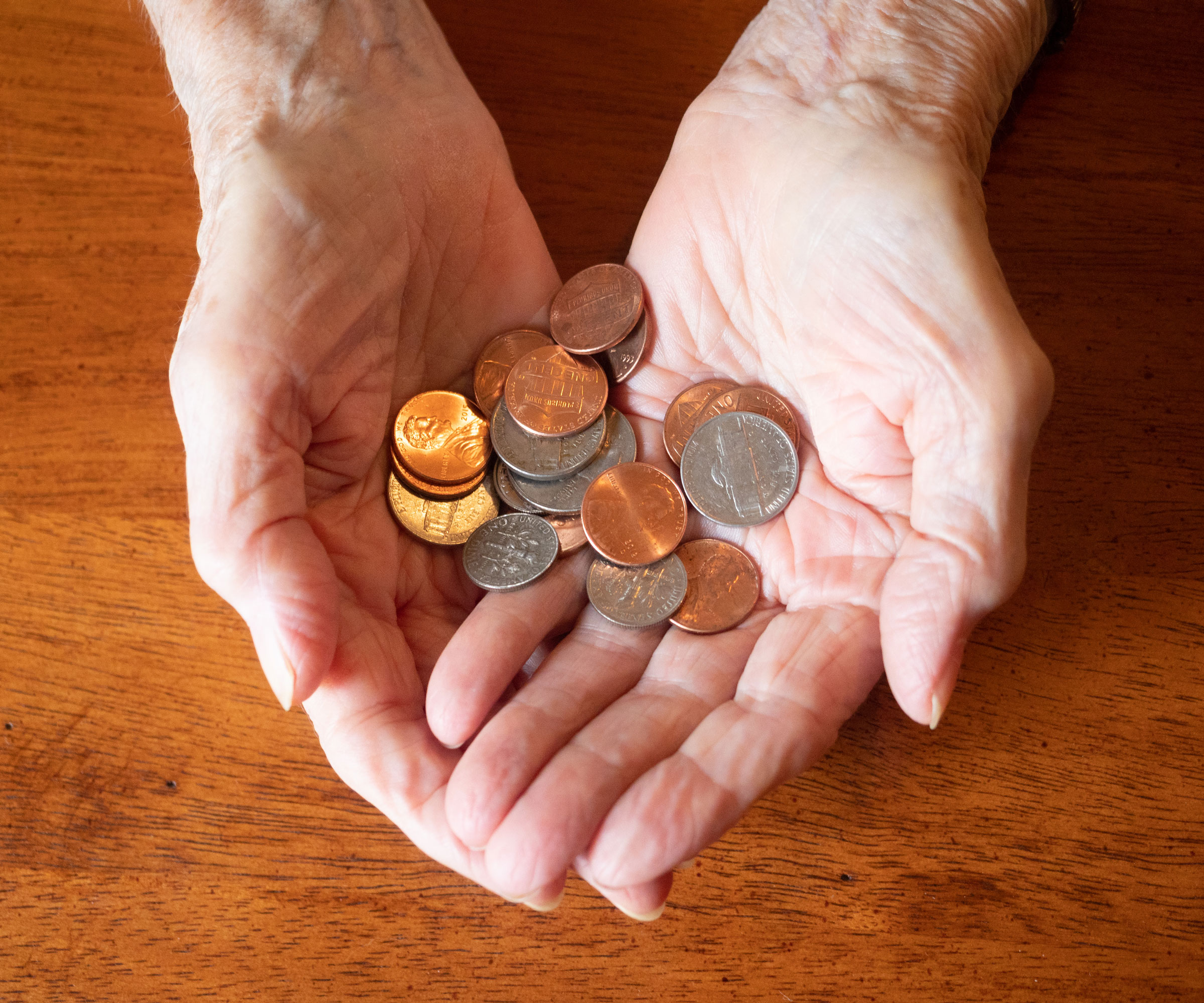 woman's hands holding pennies