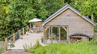 timber clad single storey house with raised decking