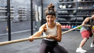 a photo of a woman pulling a rope in the gym