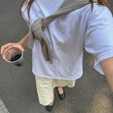 Poppy Almond in a white white and butter yellow skirt with tabis.