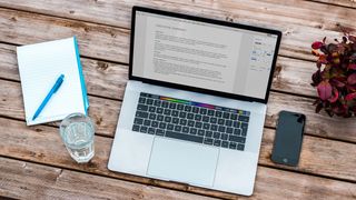 A picture of a Mac on a table with Word open