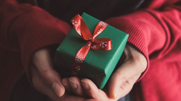 thoughtful gifts: person holding a small christmas present