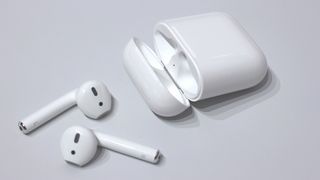 a pair of airpods with their charging case