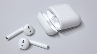 A pair of airpods with their charging case