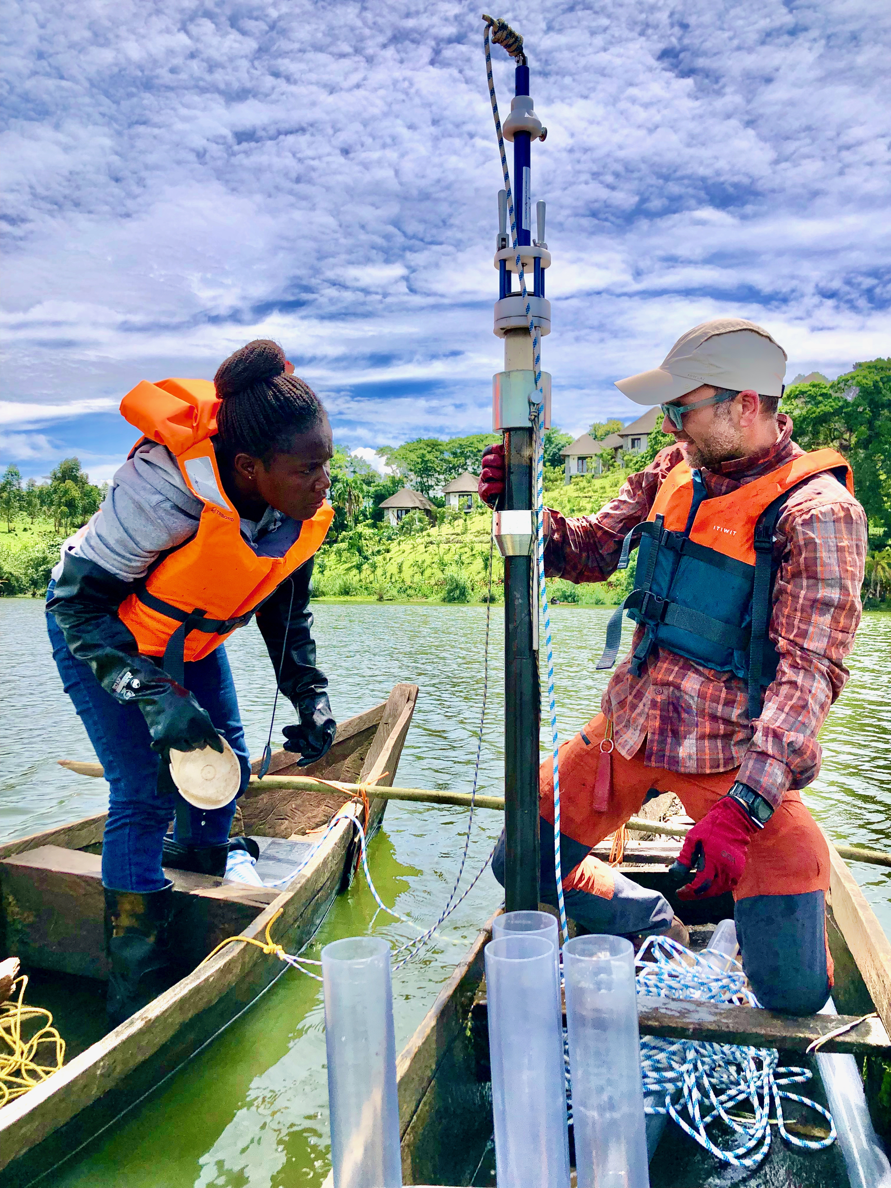 Two researchers on a boat with equipment to take samples from a lake.