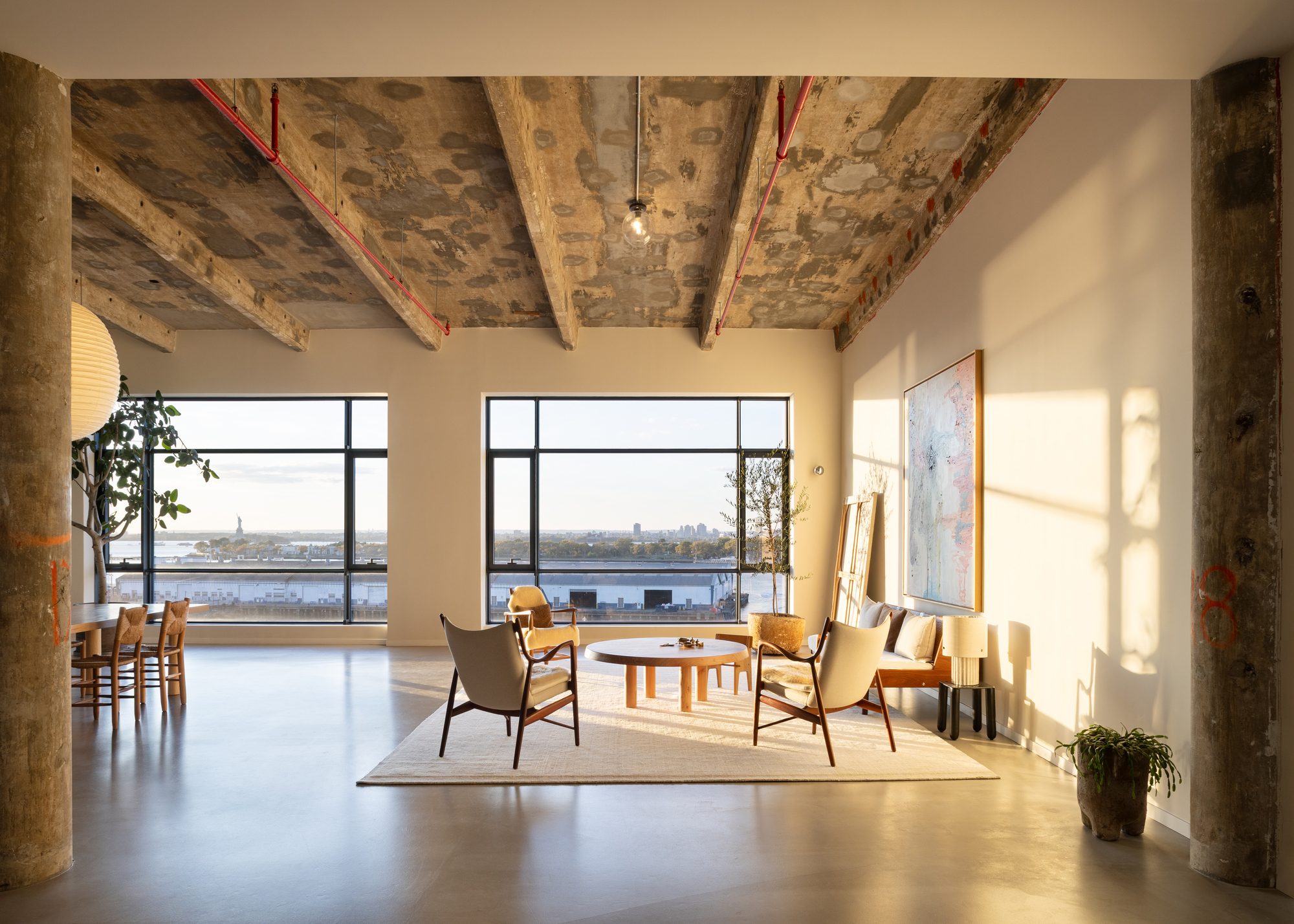 An open plan living area with two armchairs and a coffee table on a rug