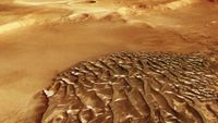 An image of metal-looking ripple on a reddish ground.
