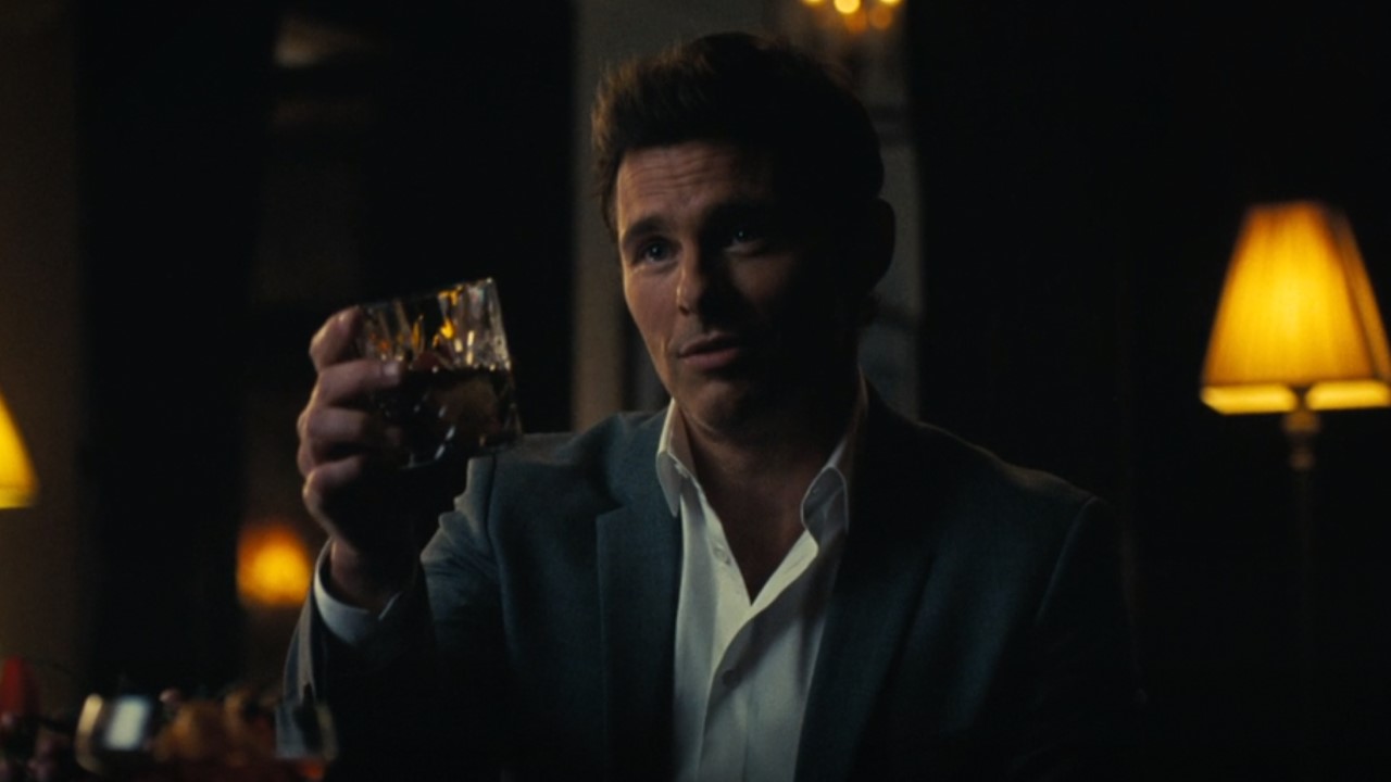 Teddy holding a glass of whiskey at Westworld